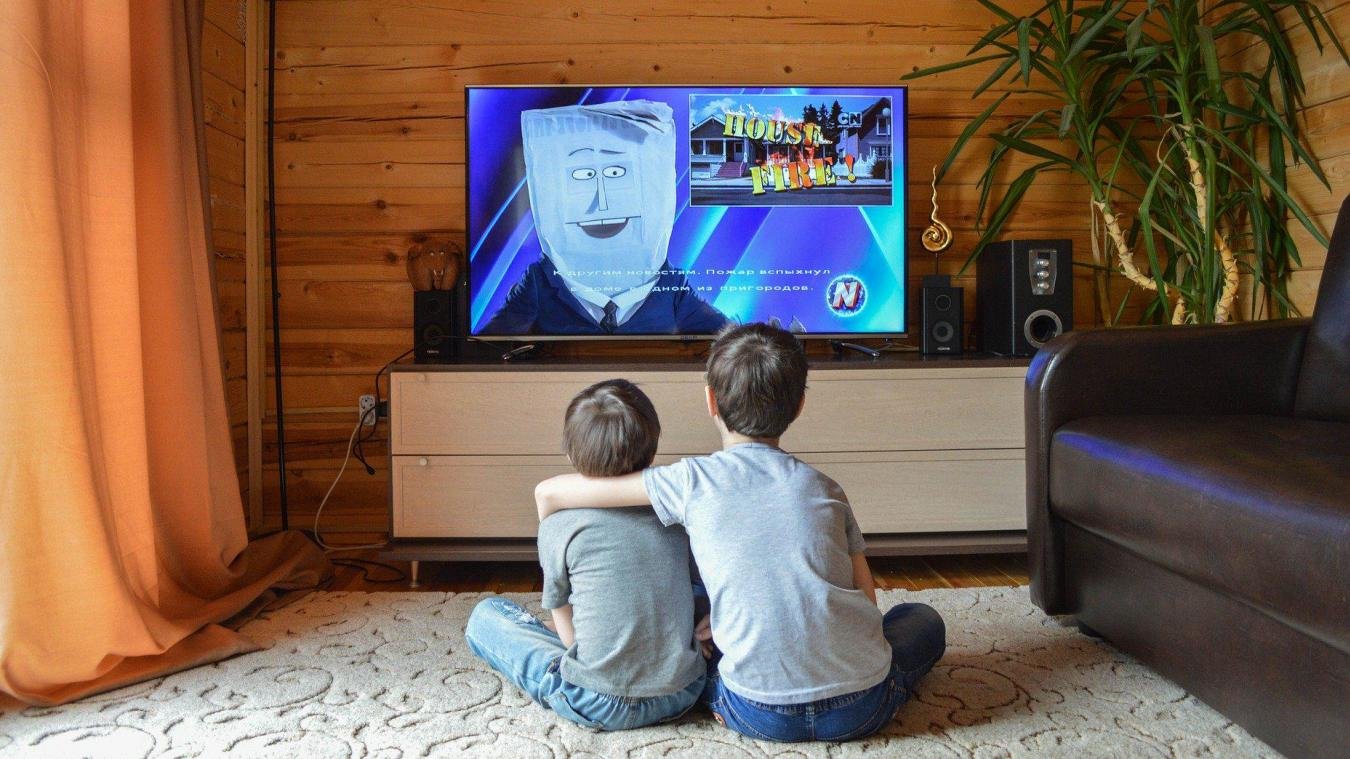Two children watching a cartoon channel from the TVStrong kids category on a living-room television